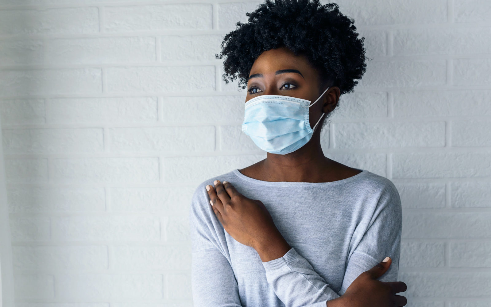 Portrait of young African-American woman wearing disposable medical face mask Portrait of young African-American woman wearing disposable medical face mask