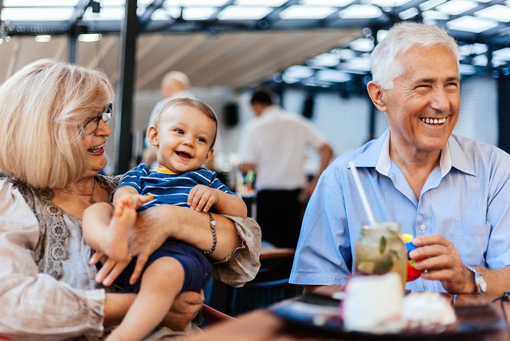 Grandparents holding child at a restaurant