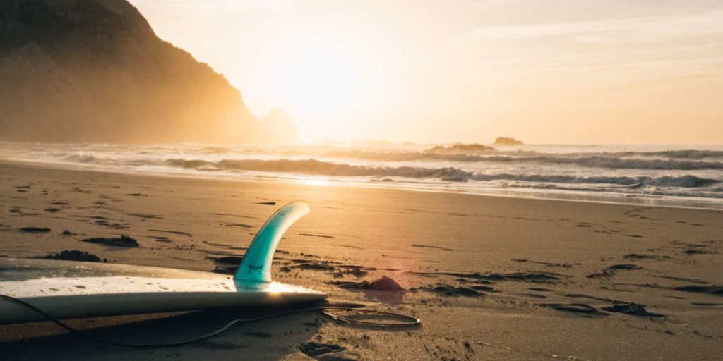 Surfboard lying on an empty beach.