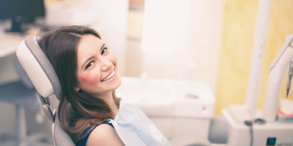 Woman smiling in dental chair before her appointment.
